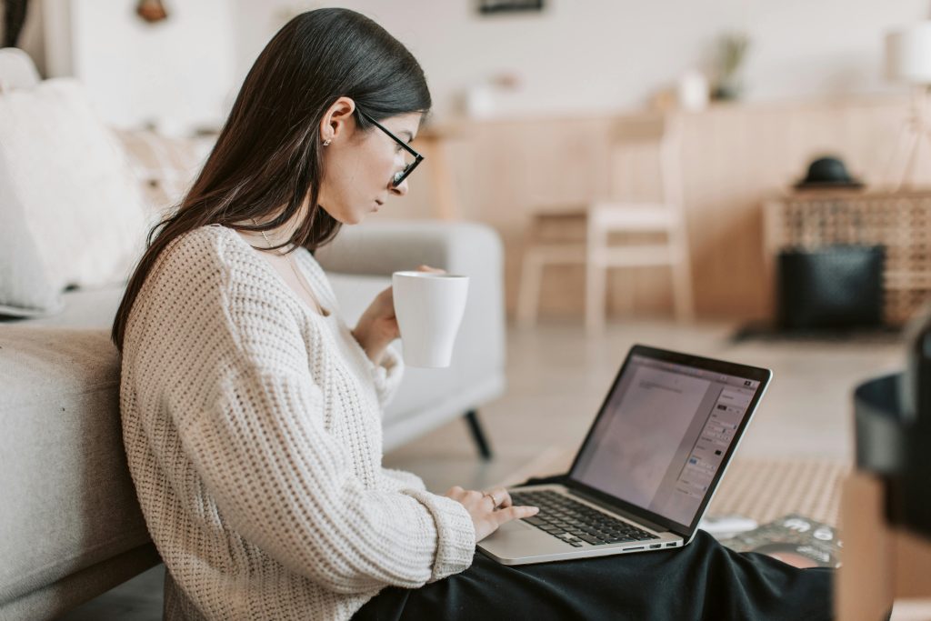 Escritora a rever um manuscrito  com computador.